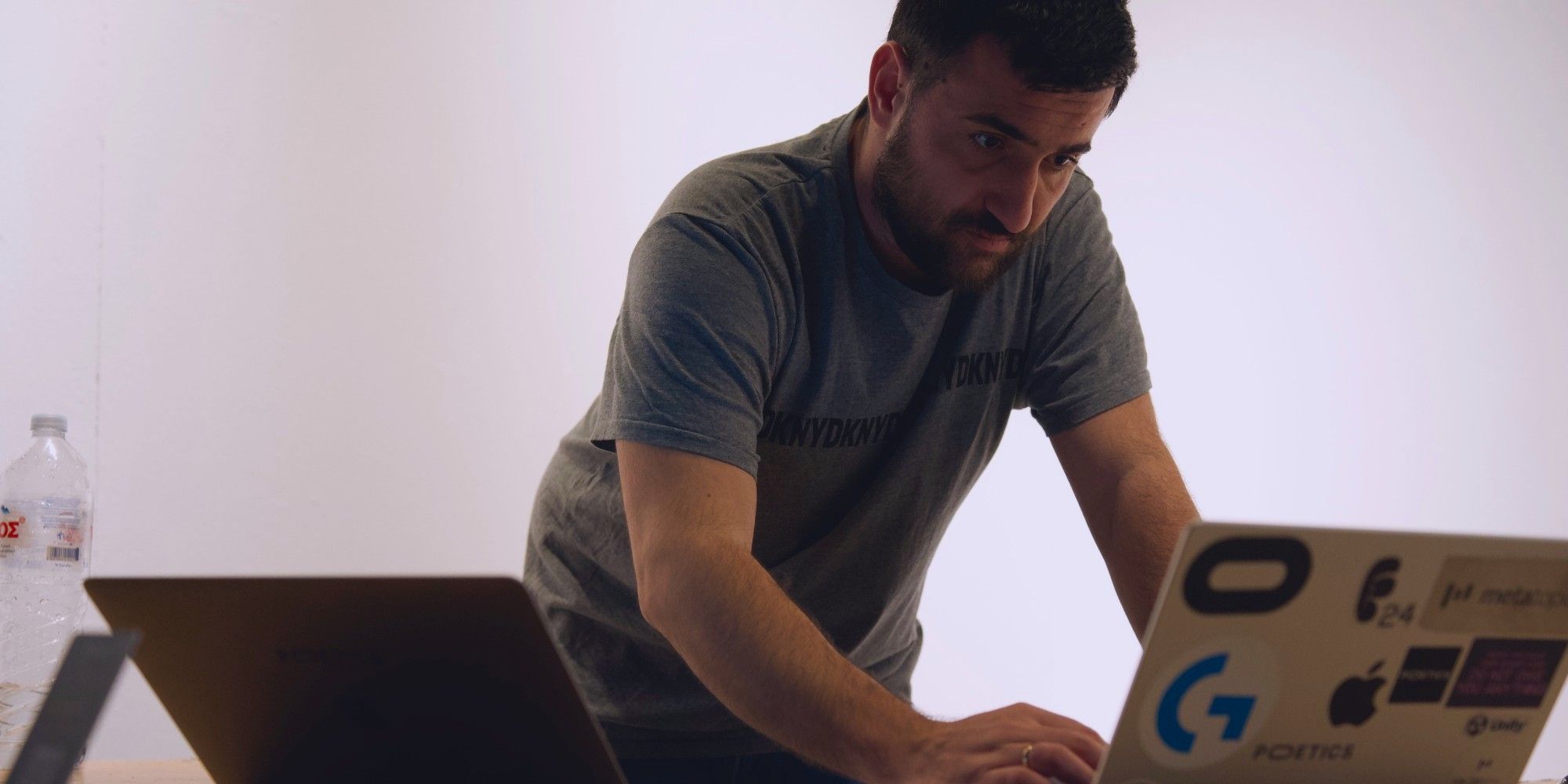 A member of the Poetics team at a laptop, setting up a session, with the Poetics letters on the table.