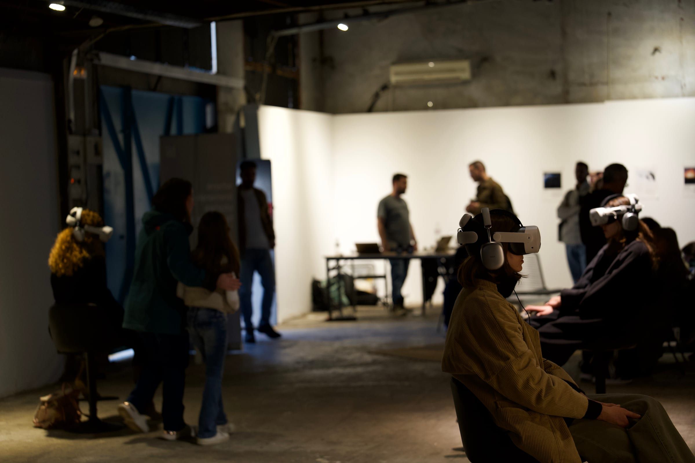 Visitors in headsets, with people moving through the gallery behind them.