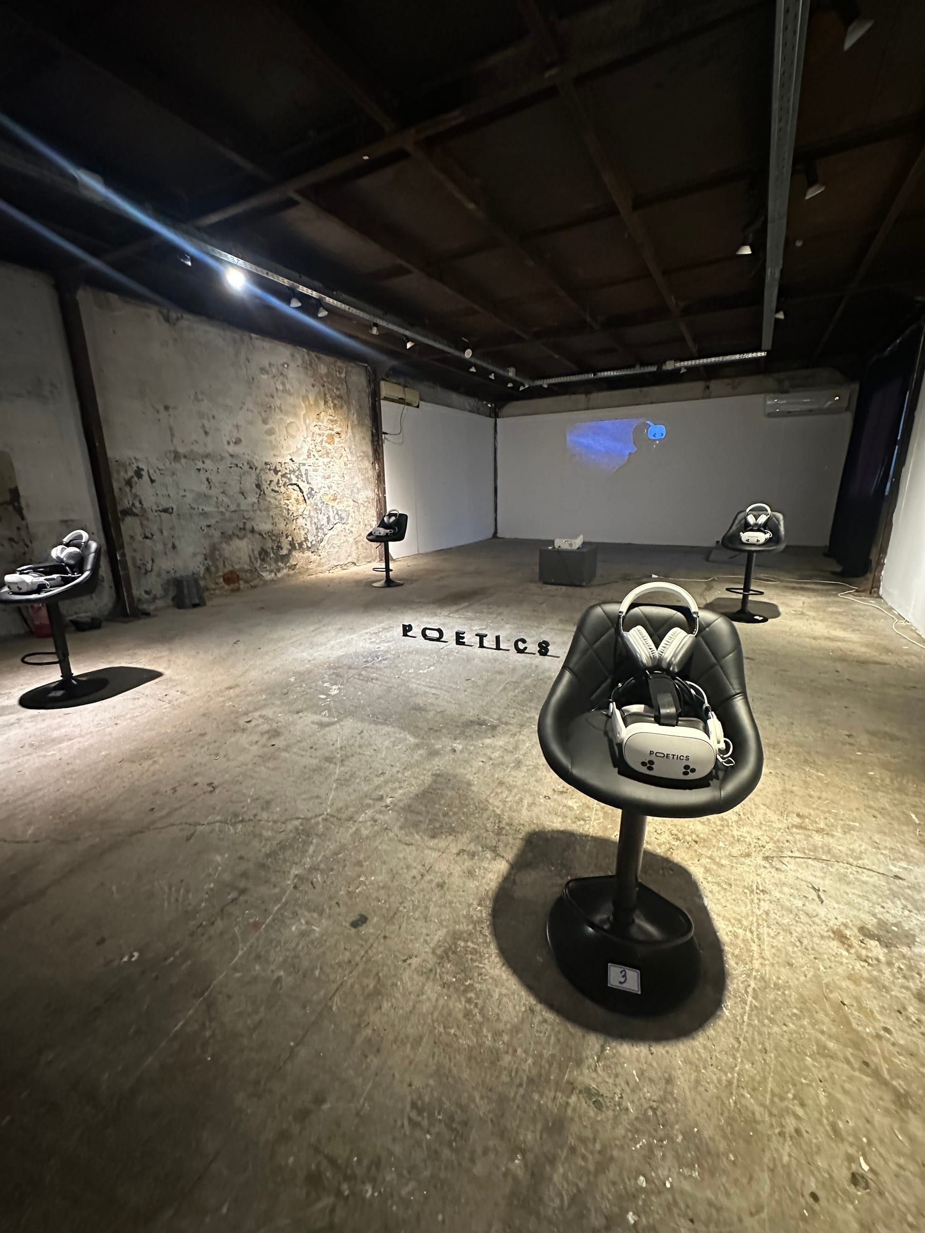 A single Poetics station in a large industrial room, with the Poetics logo on the floor.