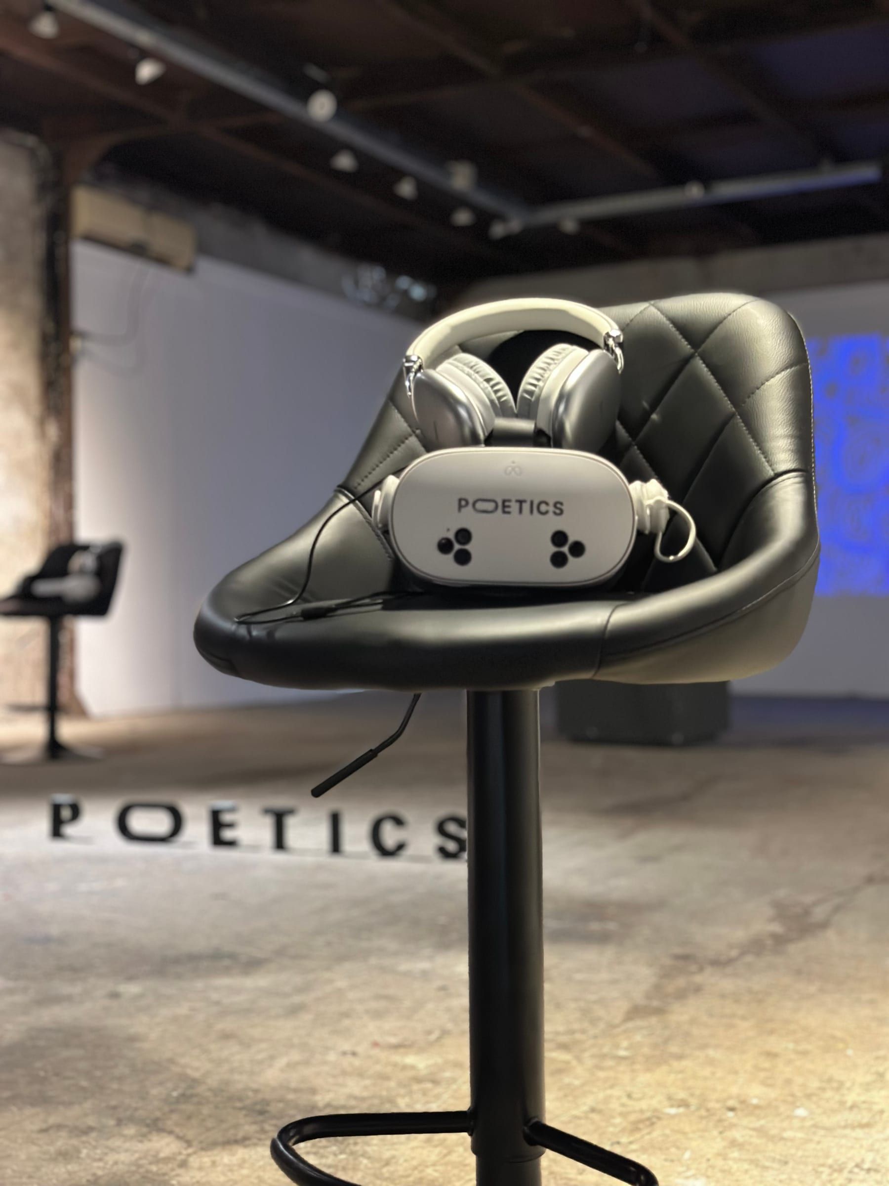 A black Poetics stool with a headset and headphones on its seat.