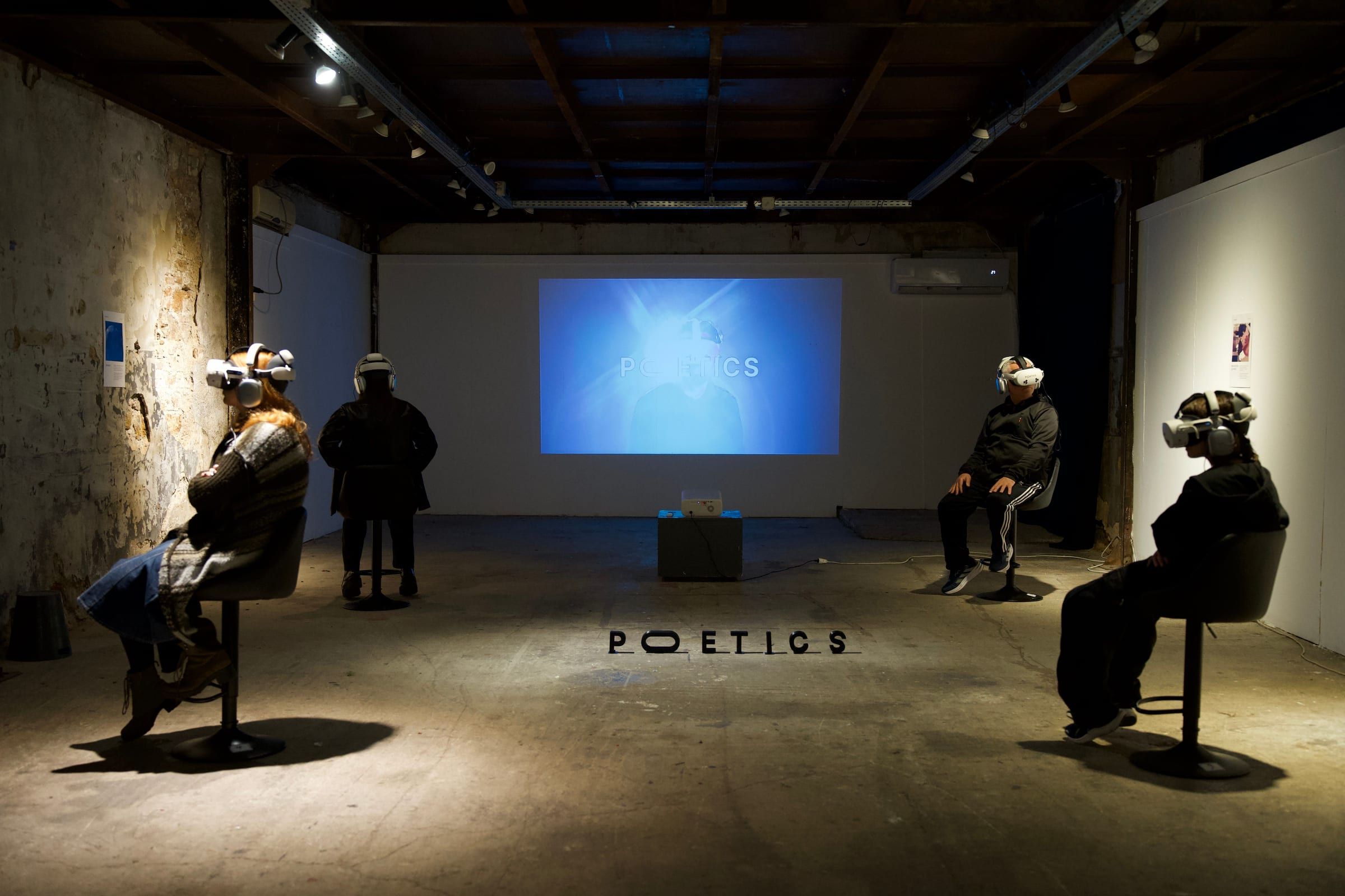 Four visitors in headsets on pods facing a projected film in a gallery, the Poetics name on the floor.