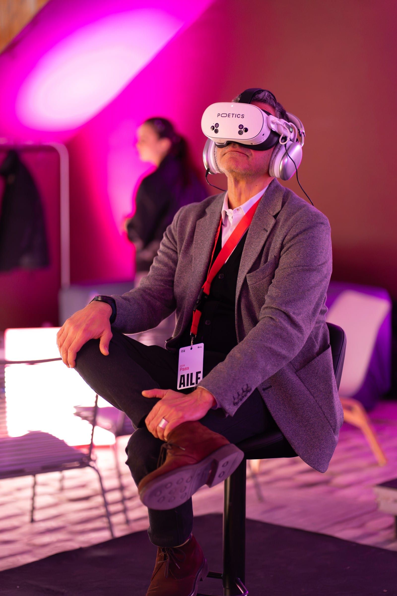 A visitor watching in a headset, wearing a festival lanyard.
