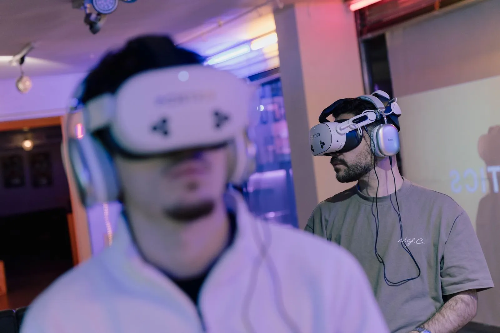 Two visitors in Poetics headsets in a cinematic setup.