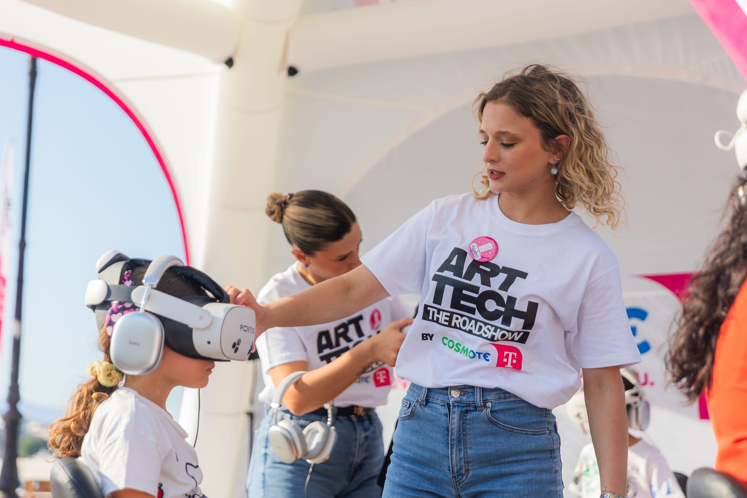 A staff member helps a young visitor with a headset.